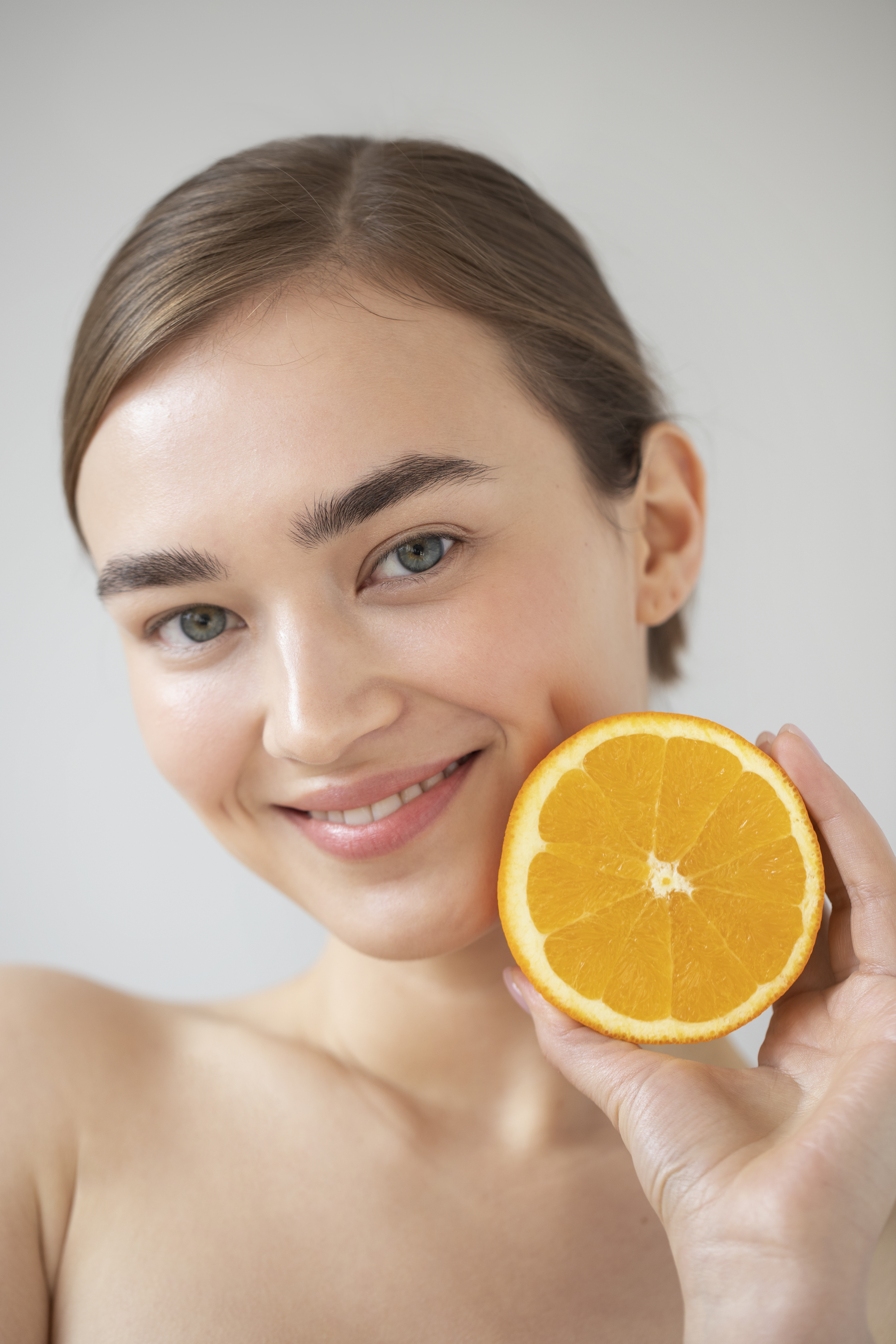 portrait beautiful woman with clear skin holding sliced orange fruit 185df
