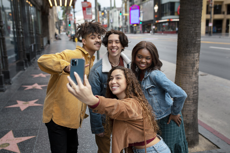 woman taking selfie with friends while out city 4d433