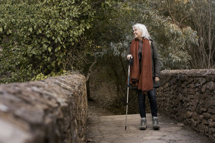 senior-woman-crossing-stone-bridge-while-out-nature_e73eb.jpg
