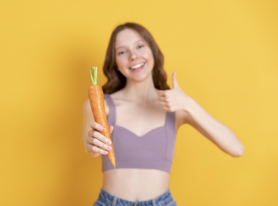 medium-shot-smiley-woman-holding-carrot_b4a89.jpg