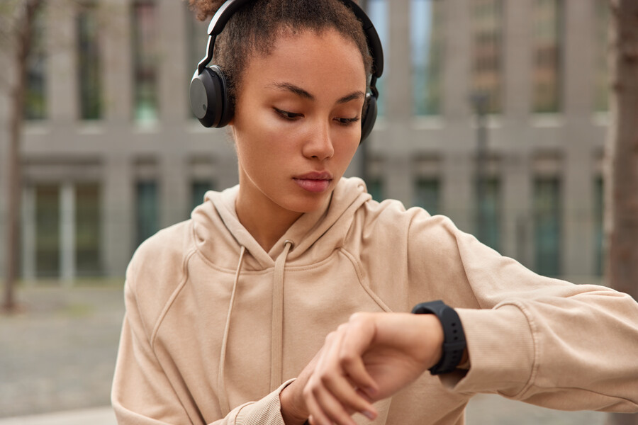 cropped-shot-sporty-woman-uses-smartwatch-outdoors-checks-burned-calories-listens-music-via-headphones-dressed-beige-sweatshirt_e31e4.jpg