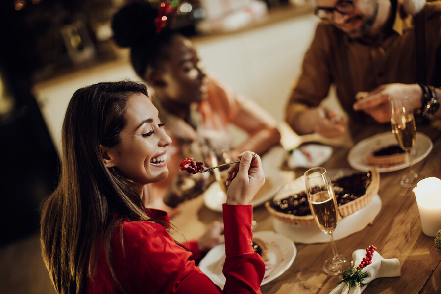 happy-woman-eating-cheery-pie-while-having-christmas-dinner-with-friends-home_a7642.jpg