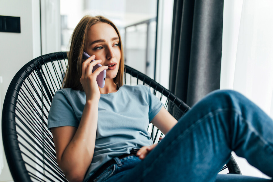 young-girl-resting-armchair-talking-phone-near-window-home_f631d.jpg