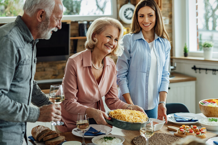 happy-senior-woman-serving-spaghetti-enjoying-with-her-family-lunch-time-dining-table_181d6.jpg