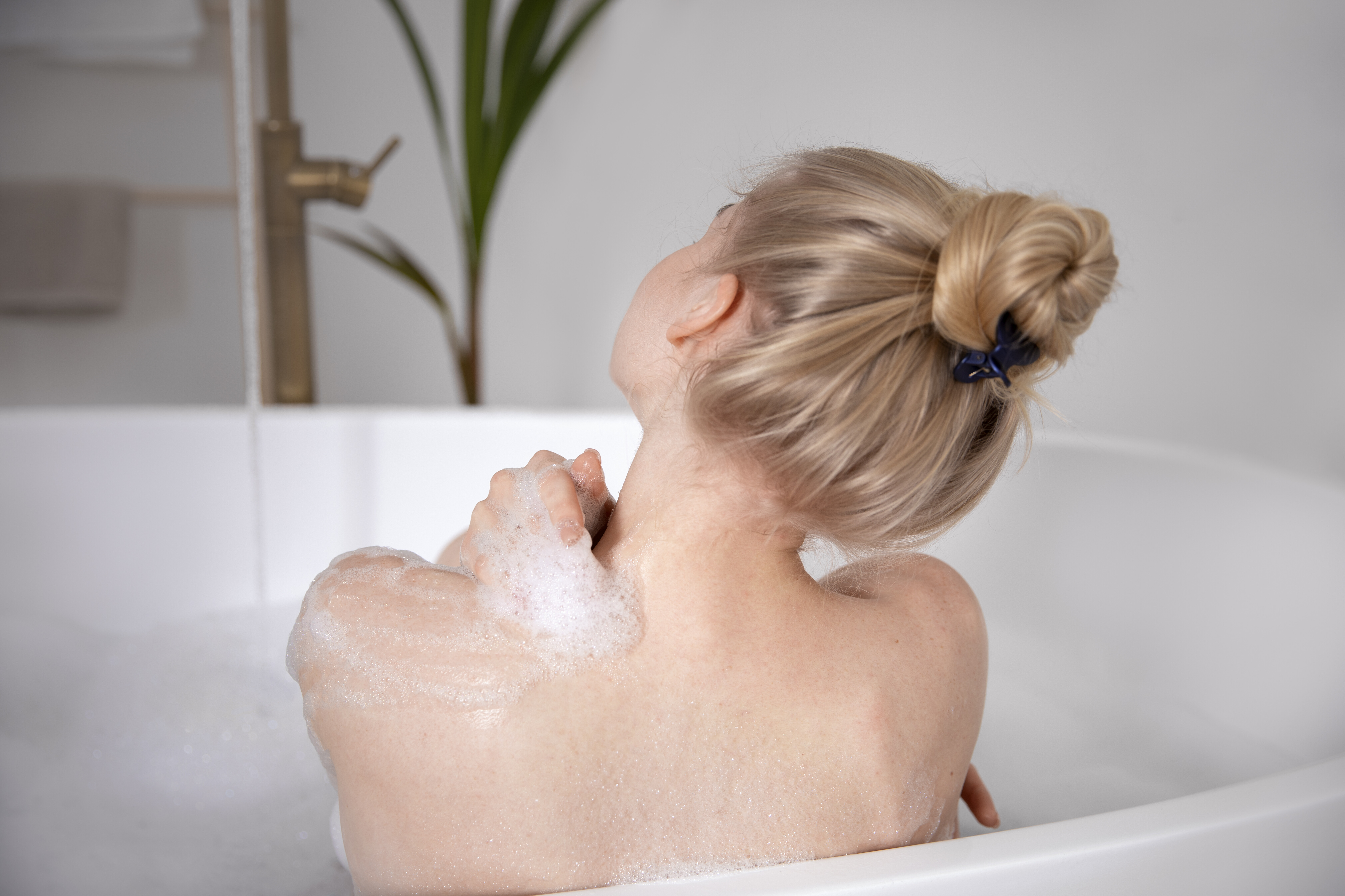 close up woman washing bathtub 89210