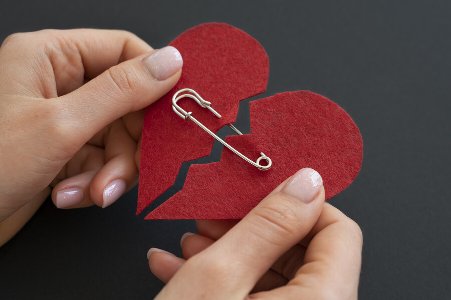 high-angle-person-holding-broken-heart-put-back-together-with-safety-pin_c5041.jpg