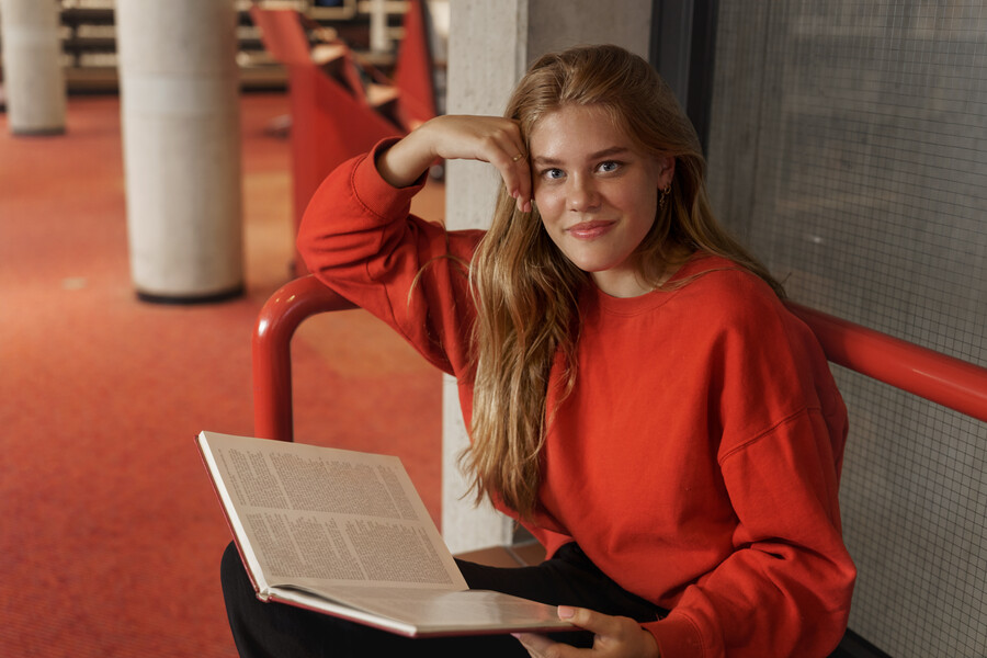 beautiful-redhead-student-girl-sitting-library-with-book-reading-prepare-examination-studying-research-looking-camera-with-pleased-dreamy-smile-learn-material-university-classes_6d391.jpg