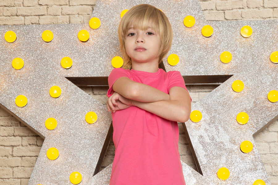 front-view-cute-little-kid-pink-t-shirt-grey-jeans-star-designed-yellow-stand-light-background_19993.jpg