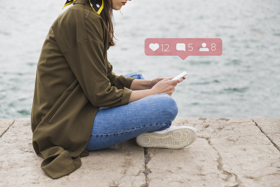 side-view-woman-sitting-pier-using-social-media-application-mobile-phone_ae4bf.jpg