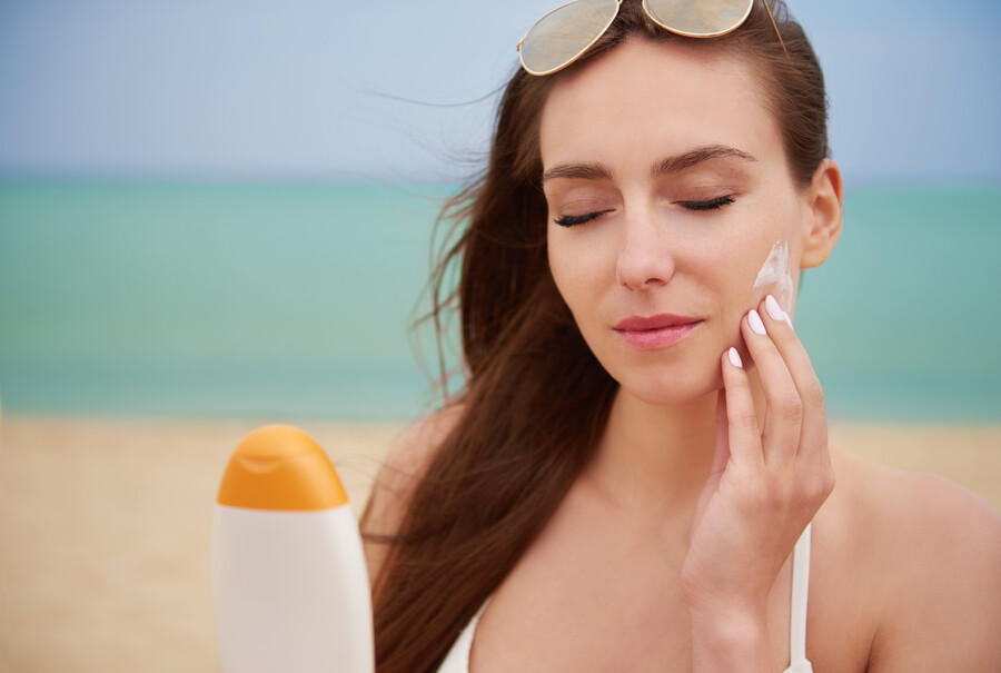 young-beautiful-woman-applying-sun-cream-beach_59ebf.jpg