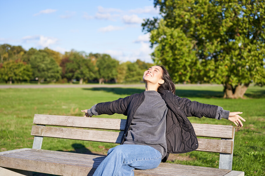 portrait-young-woman-outdoor-clothes-sitting-bench-relaxed-smiling-enjoying-view-gre_113de.jpg