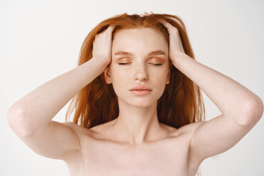 close-up-relaxed-young-redhead-woman-with-pale-skin-freckles-massaging-natural-red-hair-with-closed-eyes-standing-naked-without-make-up-white-wall_67bbe.jpg