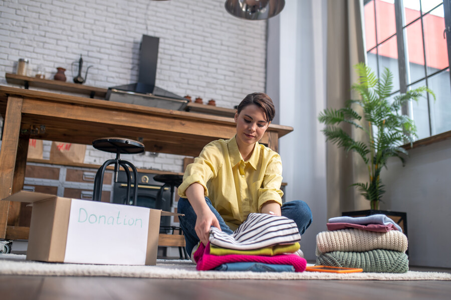 concentrated-tranquil-woman-packing-items-clothing_4a7e0.jpg