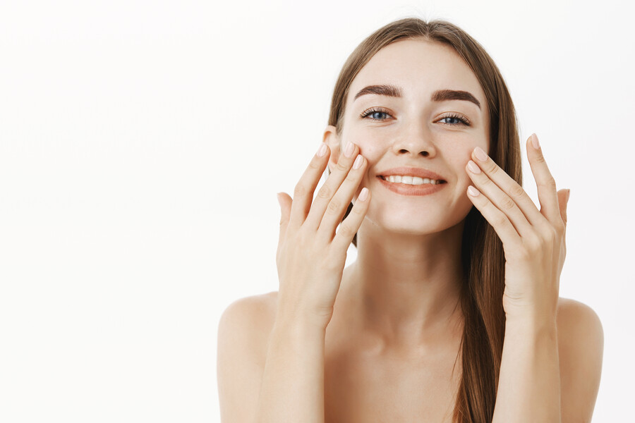 charming-relaxed-gentle-young-woman-making-cosmetological-procedure-applying-facial-cream-face-with-fingers-smiling-broadly-feeling-perfect-taking-care-skin_c93c6.jpg