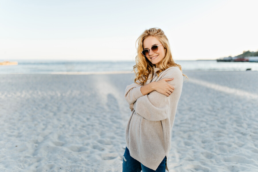 woman-oversized-sweater-jeans-posing-great-mood-beach-against-sea_7ceed.jpg