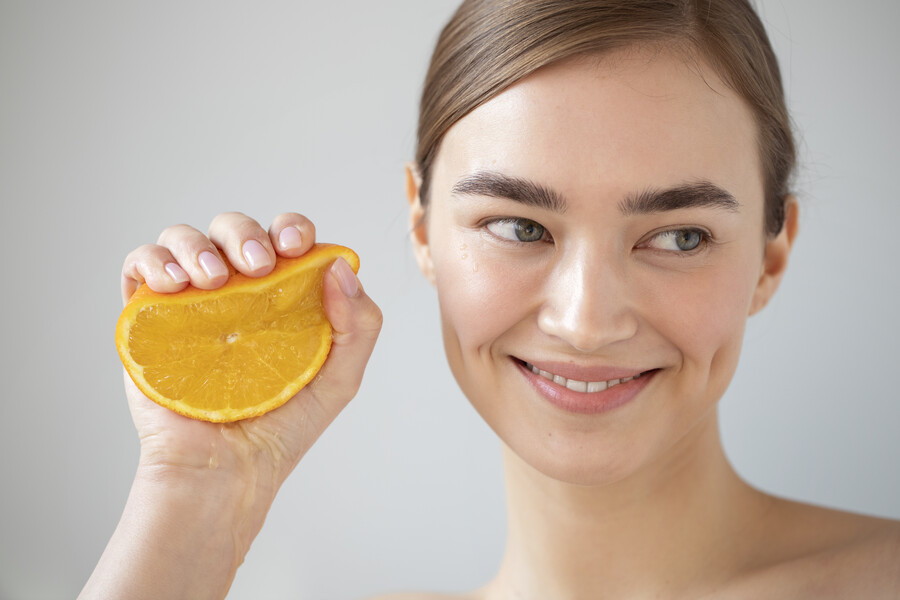 portrait-beautiful-woman-with-clear-skin-holding-sliced-orange-fruit_fb6ba.jpg