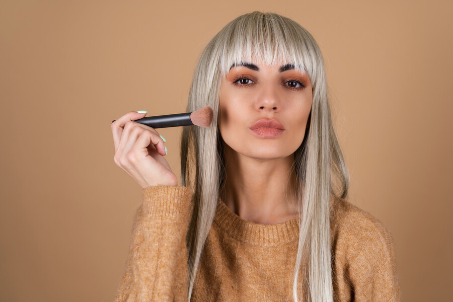 blonde-girl-with-bangs-brown-daytime-make-up-holds-brush-blush-contouring-highlighter_e12c1.jpg