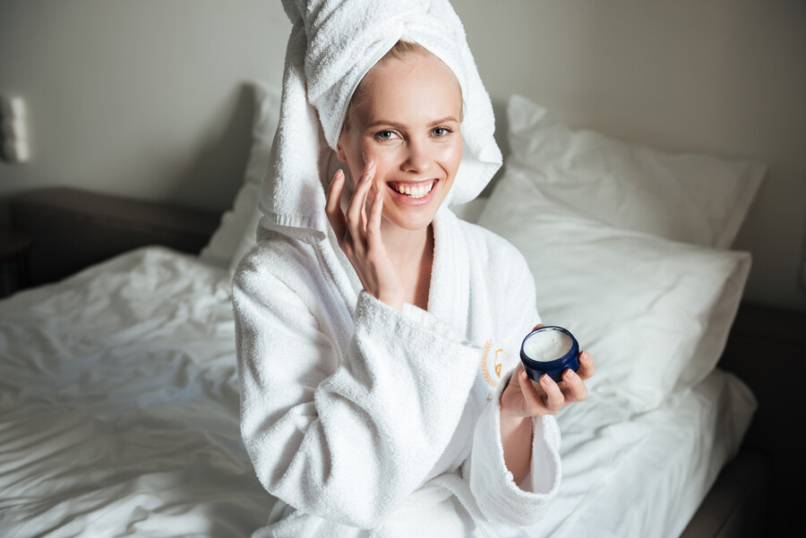 happy-smiling-woman-bathrobe-putting-cream-face_ec339.jpg