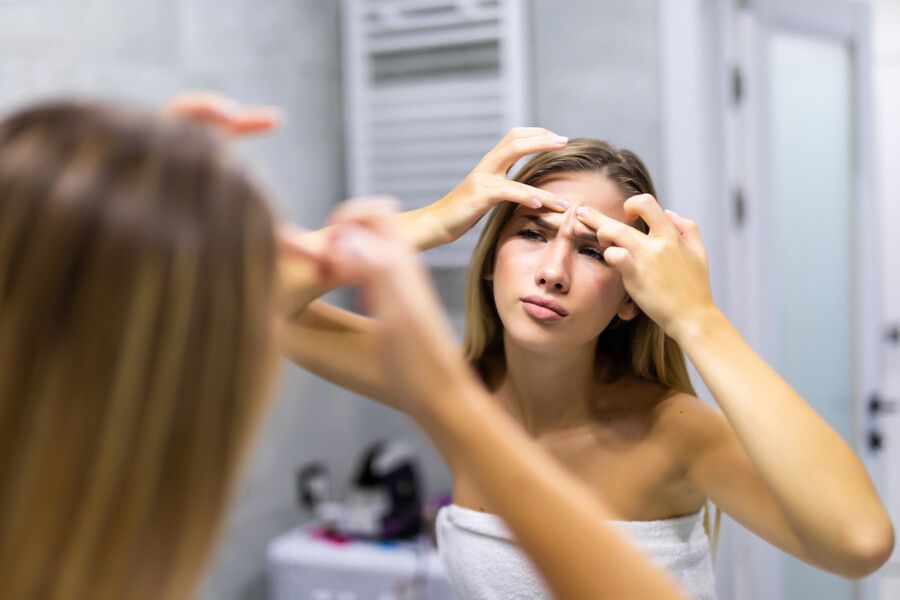 portrait-beautiful-young-woman-squeezing-pimples-while-looking-mirror_e811d.jpg