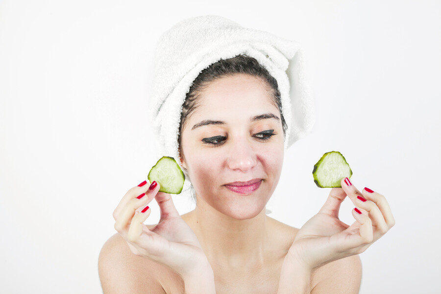 smiling-attractive-young-woman-holding-cucumber-slices-hand-against-white-background_181ca92ff916ff75.jpg