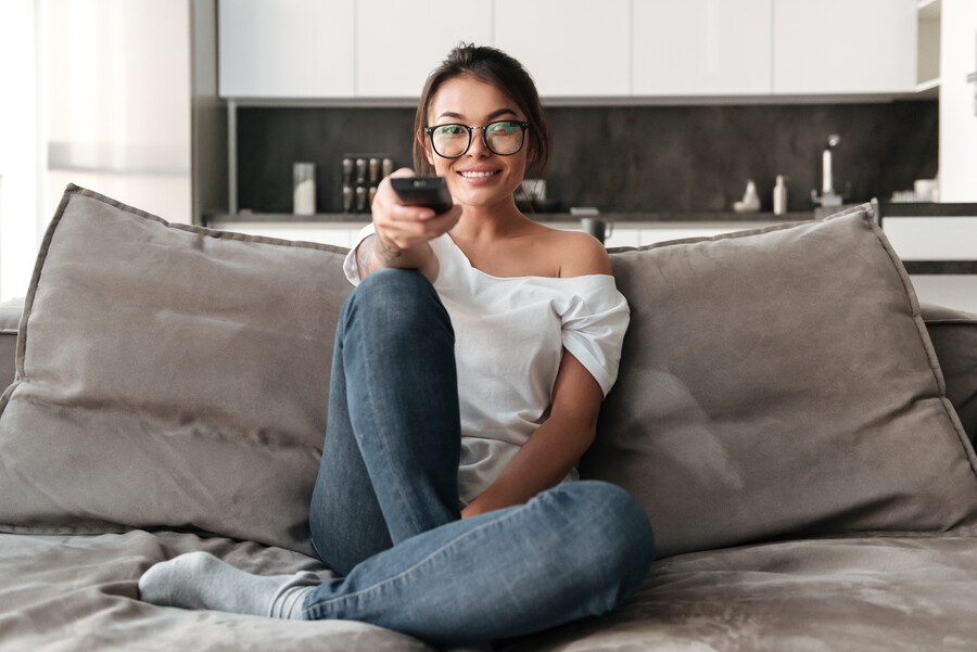 happy-young-woman-sitting-sofa-home-watch-tv_d7a93cb2023ff80b.jpg